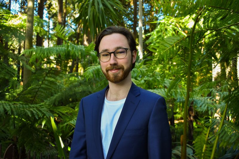 a head shot of a student wearing glasses and smiling