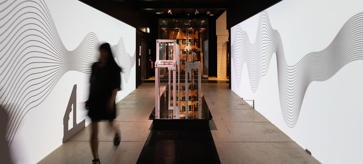 a person walks infront of a large black and white artwork projected on walks