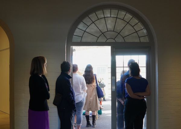 Open Day A group of people walk through an arched doorway
