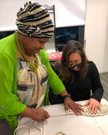 Photo: Vicki (left) facilitating a weaving event. 