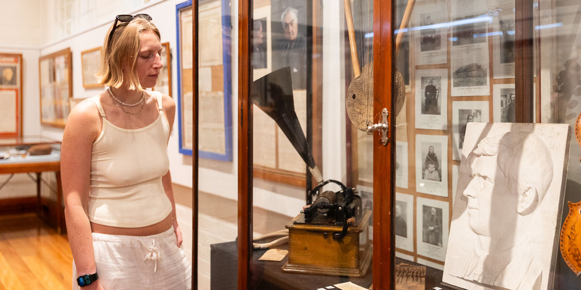 A person looks at a megaphone in a glass cabinet 