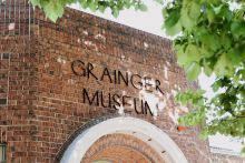 Photograph of the Grainger Museum sign. Thin metals letters spelling the name above the front entrance.