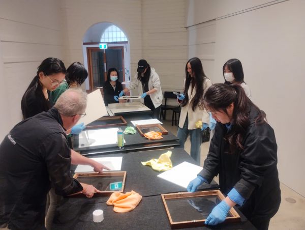 a group of students and staff prepare for an exhibition installation