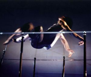 A muscular dancer jumping as though over a high jump pole.