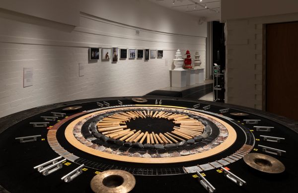 a large circular installation in a museum with photos on a distant wall